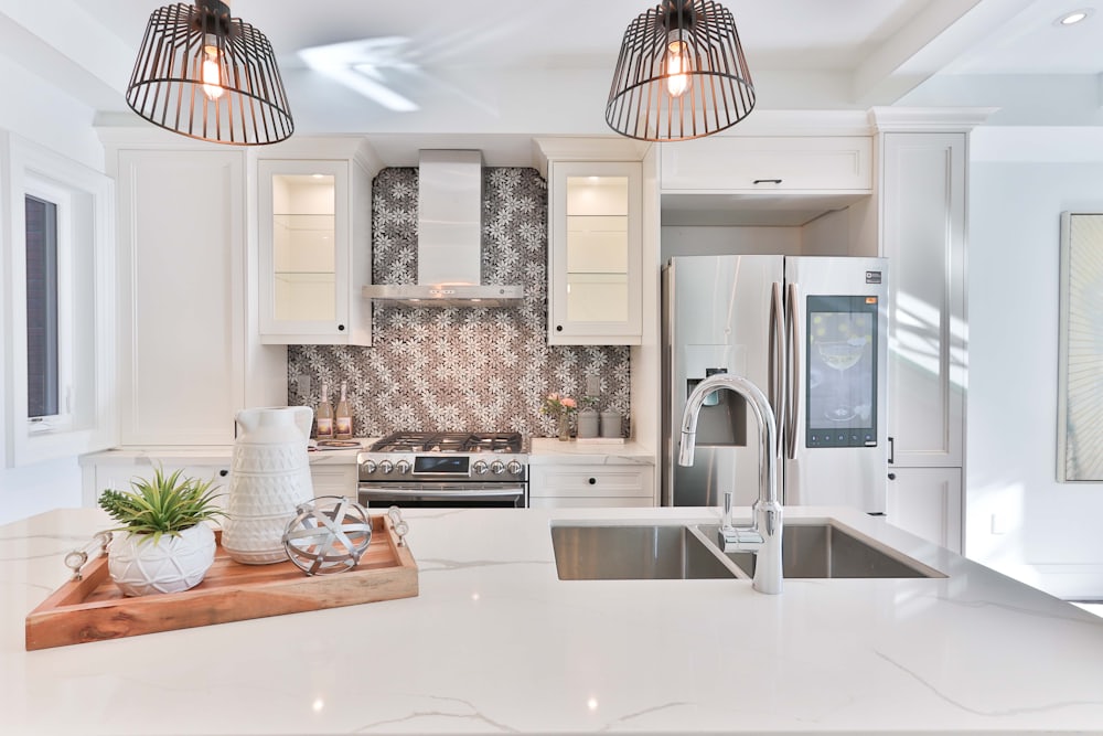 White kitchen with caged pendant lights and quartz island