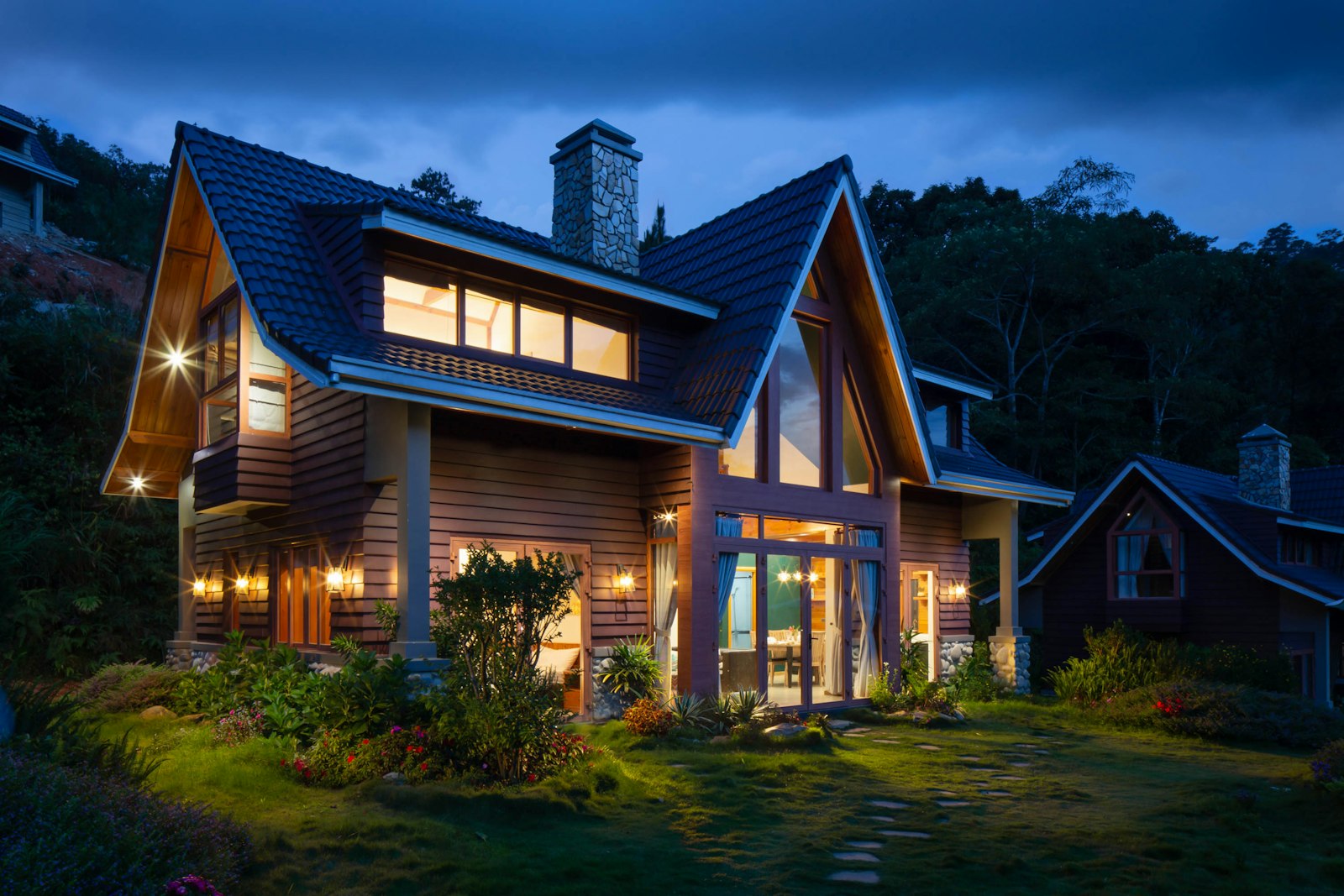 Timber home with deep roof overhangs glowing at dusk